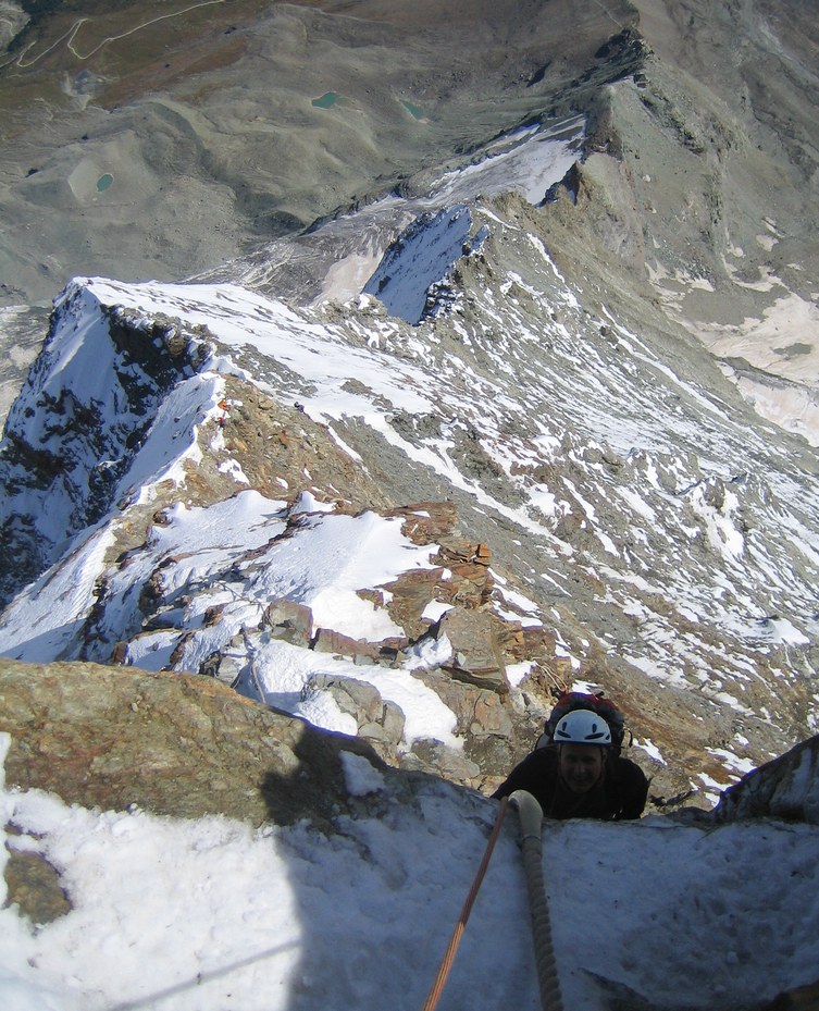 Matterhorn via Hörnli ridge: Peter climbing up the Moseley slabs with Hörnli ridge and Hörnli hut in the background Matterhorn via Hörnli ridge: Peter climbing up the Moseley slabs with Hörnli ridge and Hörnli hut in the background